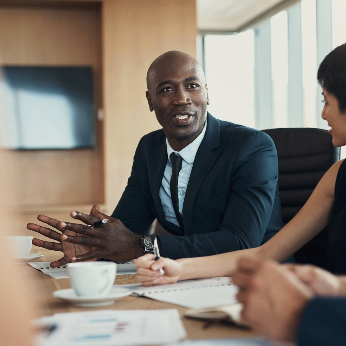 Man talking to colleagues in a meeting.