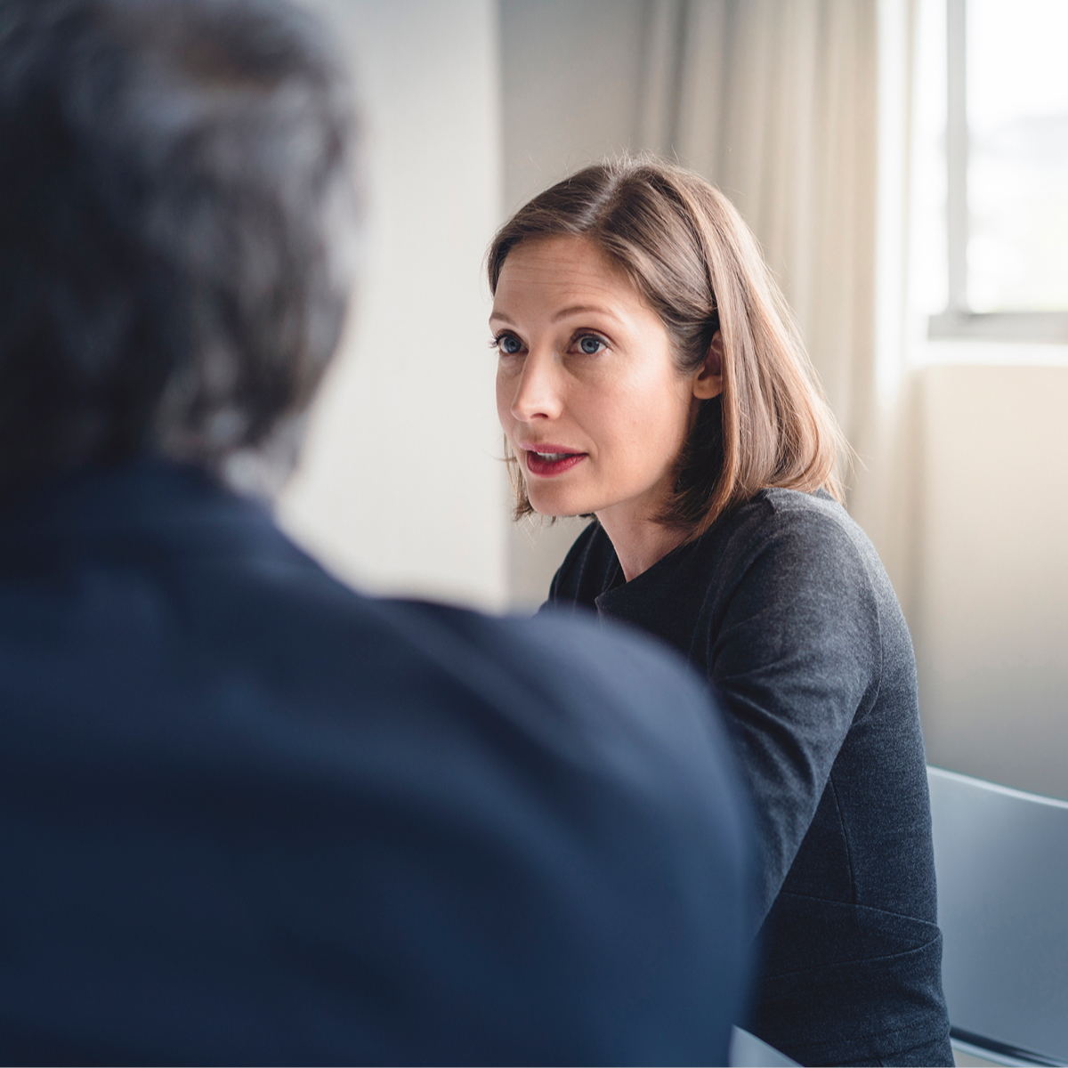 Woman in a meeting, looking another colleague